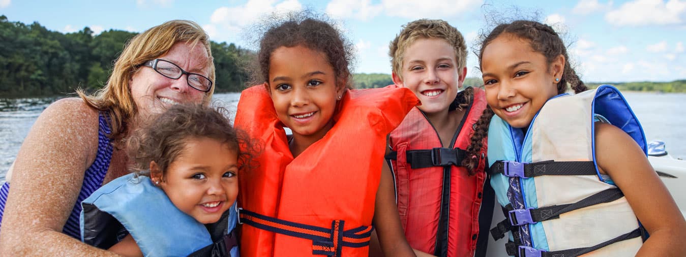 a family wearing lifejackets enjoy a day on Oneida Lake